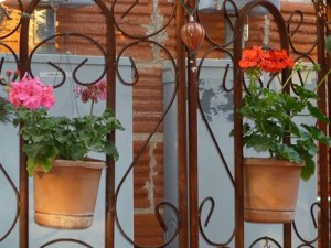 Two flower pots hanging on a metal trellis