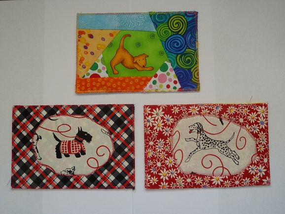 Three dog-themed fabric postcards by Tresha