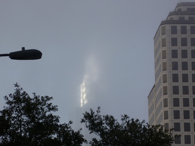 In heavy fog, morning sunlight reflecting off a building