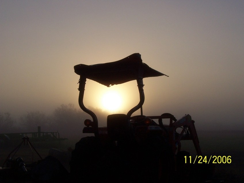 Tractor, fog and sunrise