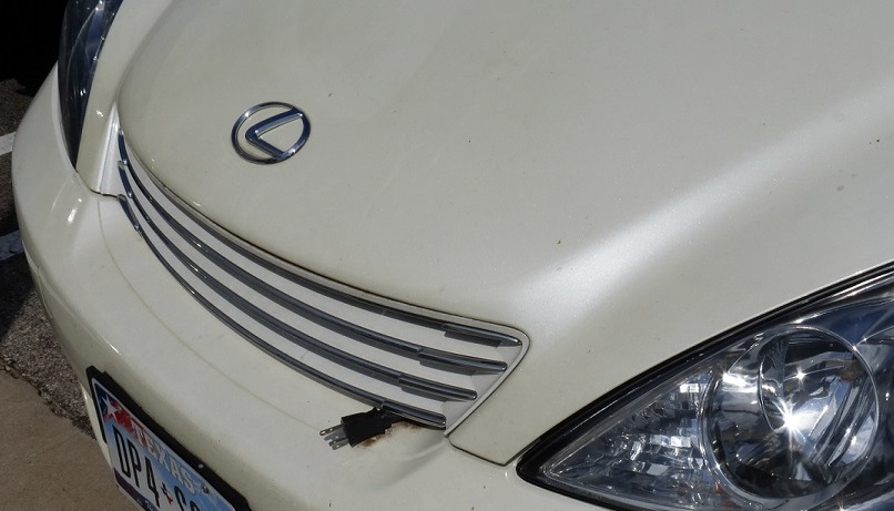 A car with an electric plug sticking out of its hood