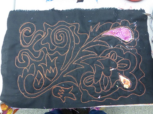 The Mola book cover design is sewed and a few sections have been cut away to show the bottom layers