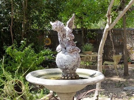 A small angel statue on top of a bird bath