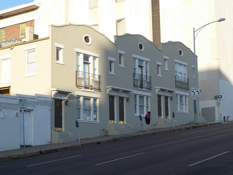 A woman walking up a street with a noticeable include