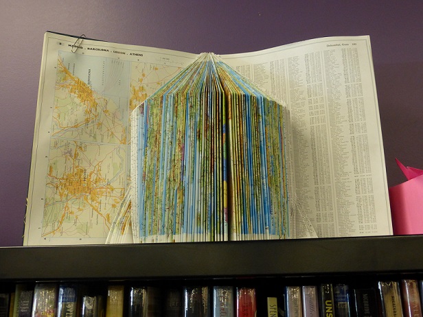 A map book with pages folded, now an art object