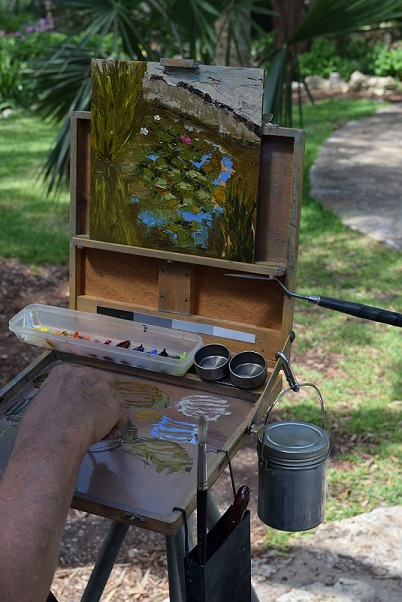 An artist painting the view of a lily pond