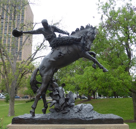 A bronco and a rider statue in broad daylight