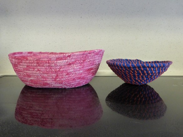 Two fabric bowls: one pink and one blue with orange trim