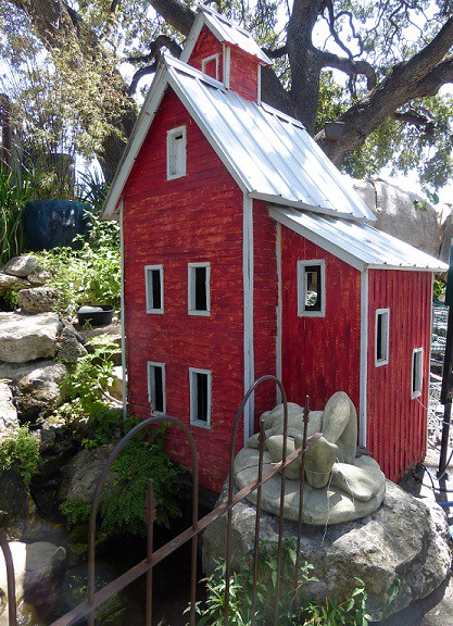 A small, red mill house at the garden center