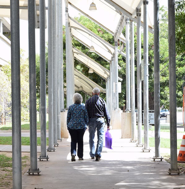 A photo of an older couple walking hand in hand