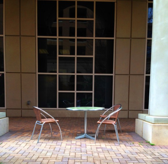 Friday Fictioneer photo prompt.  Copyright Melanie Greenwood.  Three empty chairs at a bistro table.