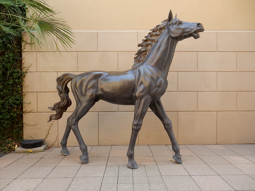 A sculpture of a small horse, movement indicated by its muscles, its hair and it being on its tiptoes