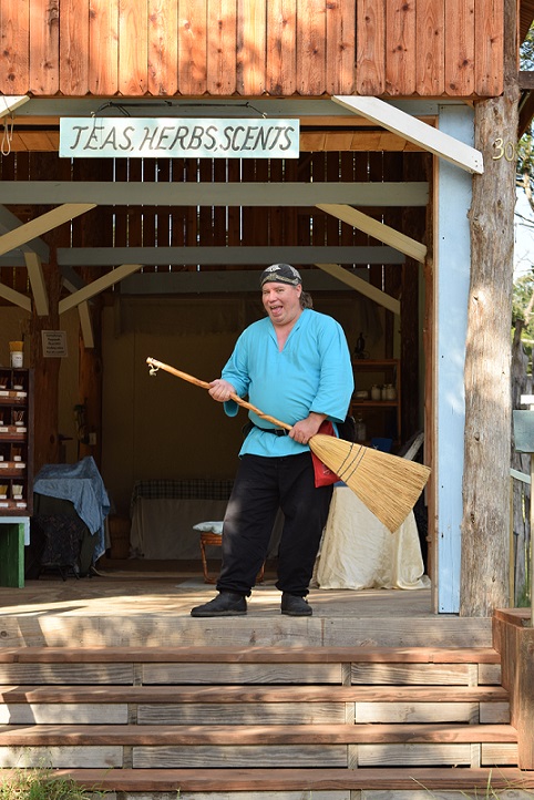 A shopkeeper sweeping the steps to his shop, getting ready to open for business