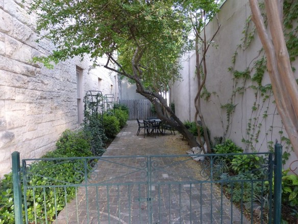 A small patio between two buildings with one table and a couple of chairs.  Serene