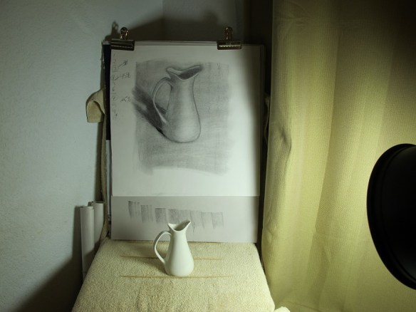 A photo of the charcoal sketch and the sketching object (the pitcher) together