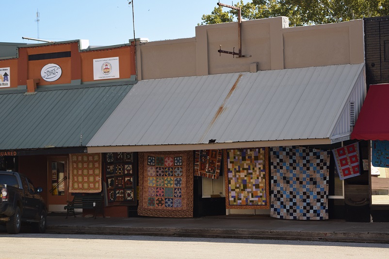 Quilts hanging in front of businesses in Smithville, Texas