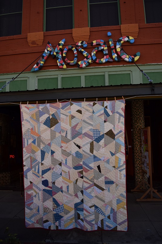 A mosaic quilt in front of an art gallery named Mosaic
