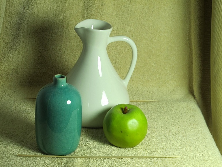 The still life objects: the vase, the pitcher, the apple