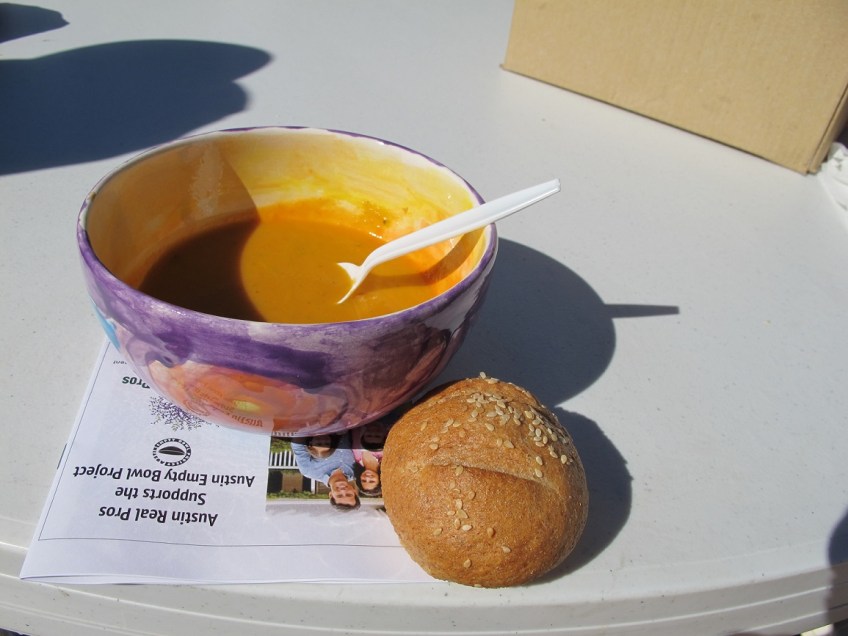 My ceramic bowl filled with pumpkin soup next to a bread roll