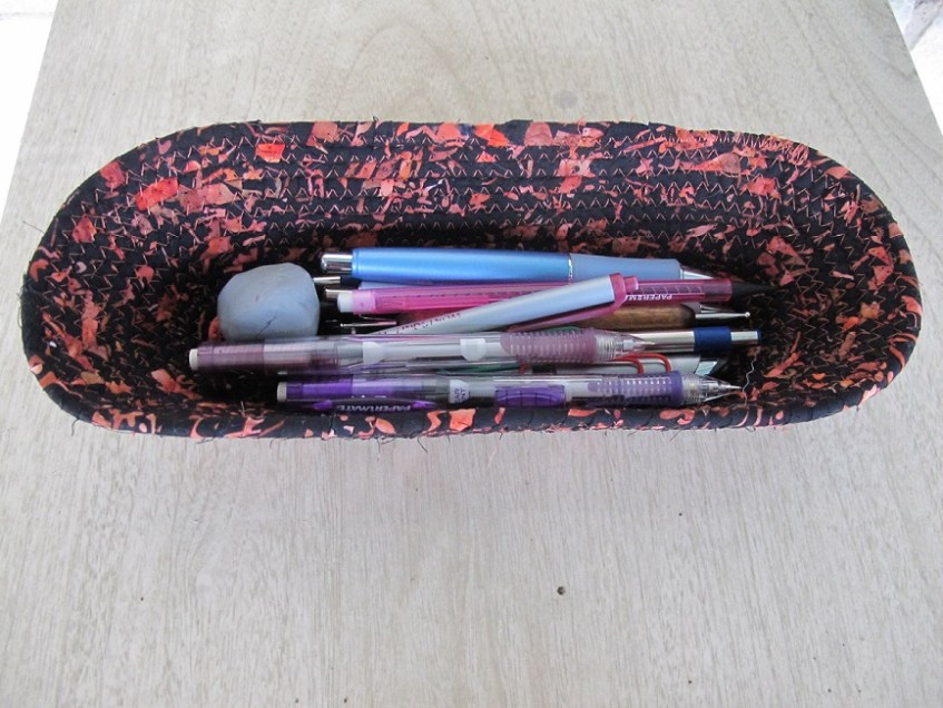 Bowl with pens, pencils, and eraser