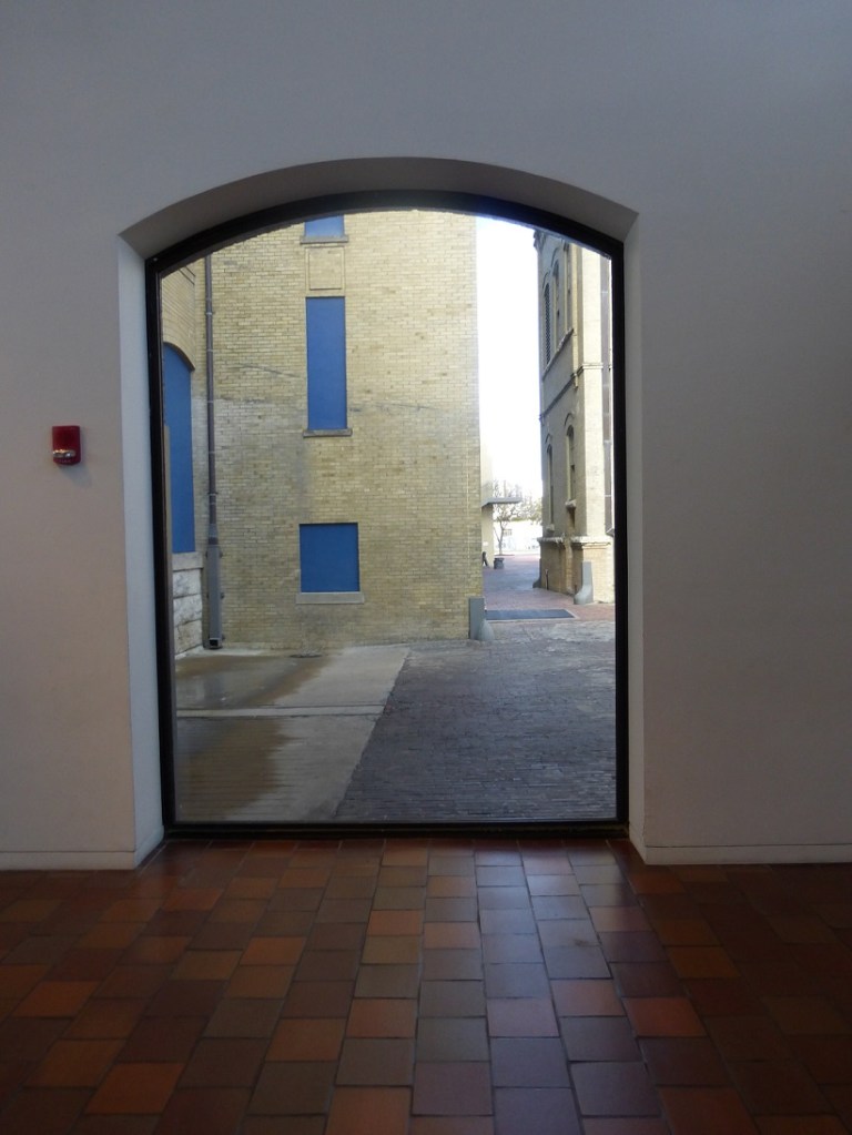 A photo of a window looking out to a courtyard at the San Antonio Museum of Art
