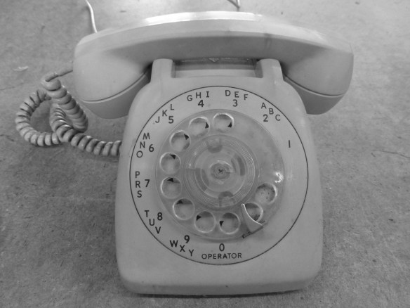 An old, rotary phone in a black and white photo