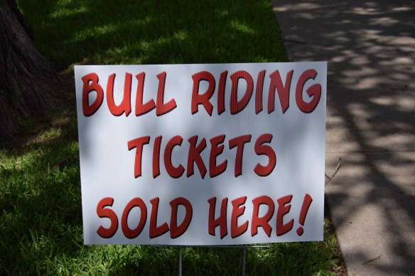 Sign that reads "Bull riding tickets sold here!"