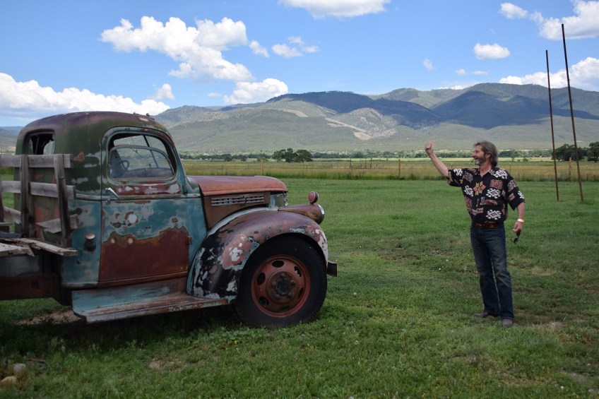 Old GMC pickup with a man in front of it, as if he is hitchhiking